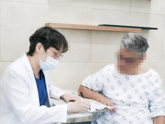 Doctor discussing care with a patient seated on an examination bed