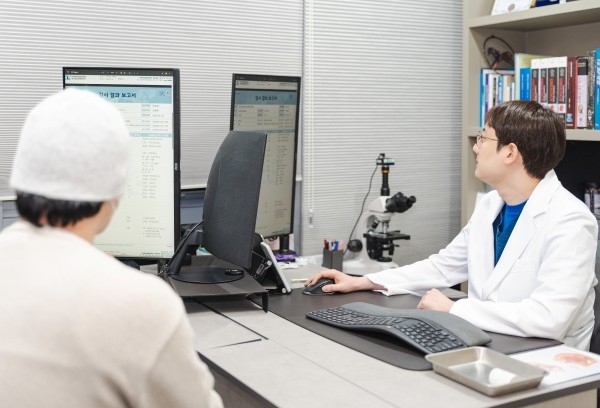 Urologist reviewing information on screen with a patient