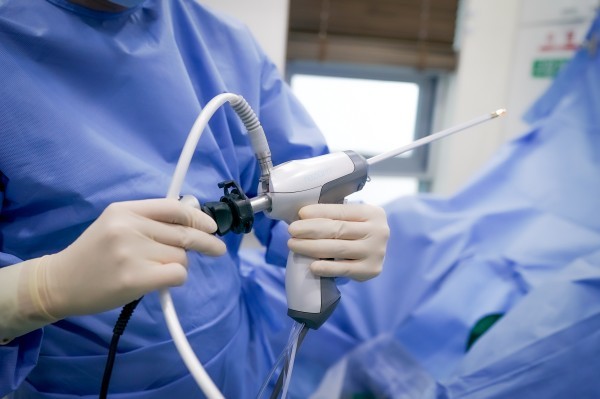 Close-up of a clinician holding an endoscopic instrument
