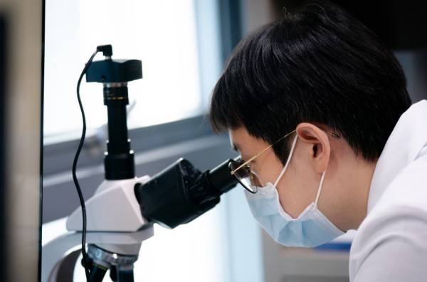 Clinician looking through a microscope