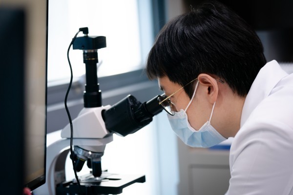 Clinician looking through a microscope