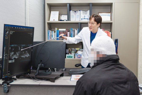 Urologist pointing to examination findings on a monitor